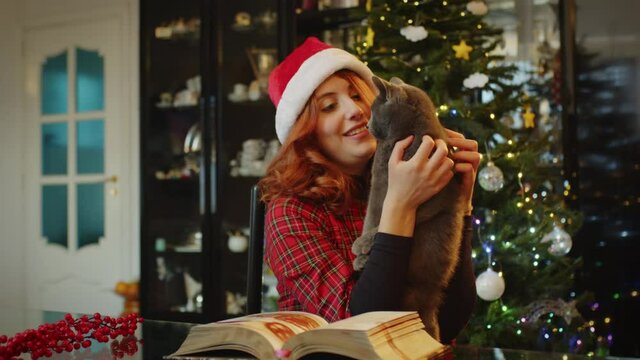 Ragazza con gatto e albero di Natale in casa