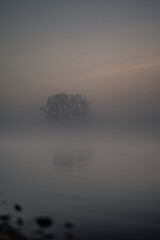 misty stree over a foggy lake in th evening