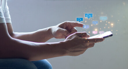 Social media interactions on mobile phone, concept with notification icons of like, message, email, comment and star above smartphone screen, person hands holding device, internet digital marketing