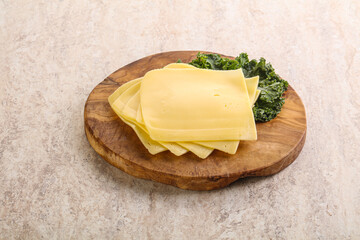Sliced Gouda cheese over board
