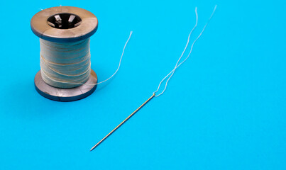 a spool of thread and a needle with a thread