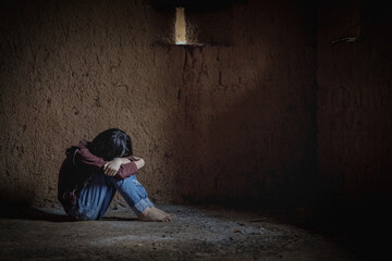 little girl sitting alone in an old empty room. Human trafficking concept,
