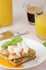Breakfast with a sandwich with poached egg and avocado	