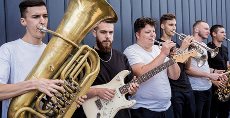 Young street music band play a lot of musical instruments
