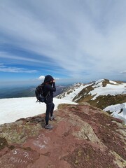 A woman is photographing at the highest peak in Serbia, Midzor, Stara planina 