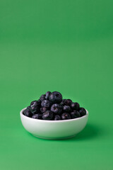 Blueberries on green vertical background