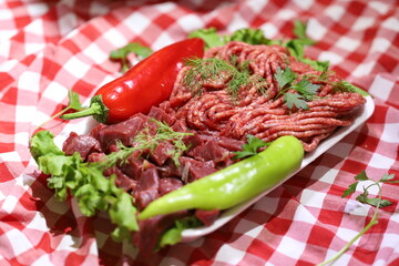 Meat varieties presented with fresh vegetables in plastic plates.