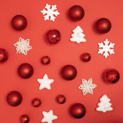 Red and Christmas baubles decoration on red background. New Year greeting card. Minimal style. Flat lay.
