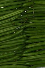 Close-up of fresh green beans lined up. Immature pods of common beans. Vegetable for vegetarian. Food for vegan.