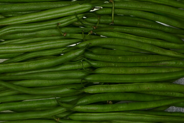 Close-up of fresh green beans lined up. Immature pods of common beans. Vegetable for vegetarian. Food for vegan.