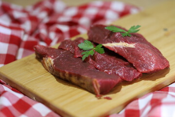 Meat varieties presented with fresh vegetables in plastic plates.