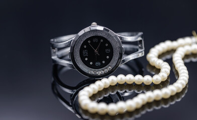 Women's watch in the original metal case and a pearl necklace