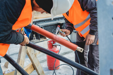 Two electrician builder workers installing high-voltage cable