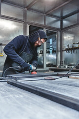 Loud and Fast. Mechanic steel. Grinding. Man holding hand grinder.