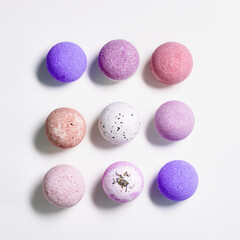 Flat lay composition with bath bombs pink, violet, purple colored on white paper background....