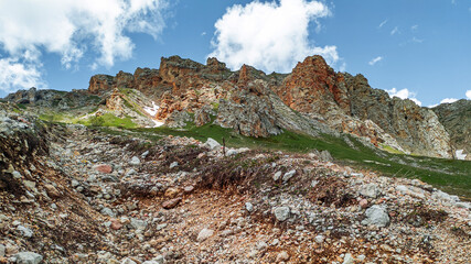 White clouds come out from behind a high cliff. Mountain landscapes.