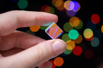 Optical glass cube in hand  Light dispersion,spectrum. Physics optics ray refractions