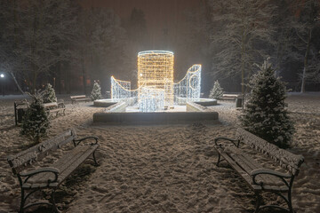 Świąteczna iluminacja w parku dworskim w mieście Iłowa w Polsce. Jest zimowa noc, widok jest...
