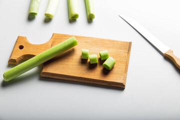 Minimal looking leeks view during slice progress over white, indludes copy space.