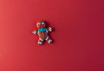 plasticine homemade figure, gingerbread, symbols of Christmas and New Year on a red background