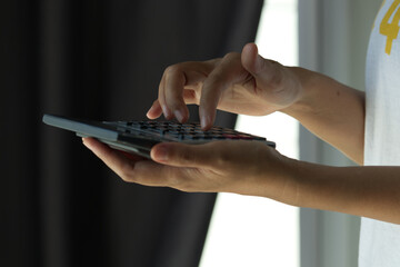 Female entrepreneur using a calculator with pen in her hand calc