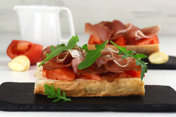 Spanish tapos with hamon, italian bruschetta with proscuitto on a black slate