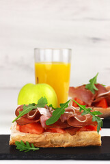 Spanish tapos with hamon, italian bruschetta with proscuitto on a black slate