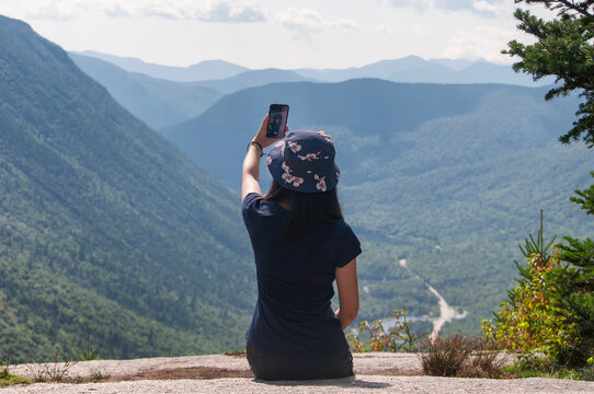 a chinese woman taking pictures on top of mount willard