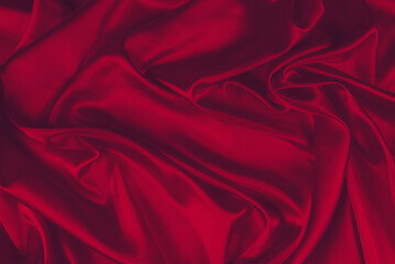 Red silk or satin luxury fabric texture can use as abstract background. Top view.