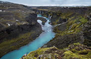 Autumn snowfall on picturesque waterfall Sigoldugljufur  view. Season changing in southern Highlands of Iceland.