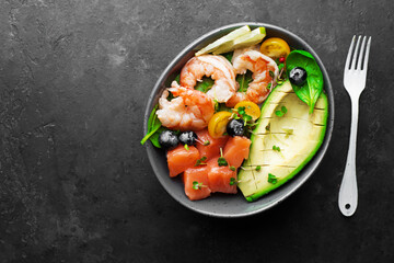 Salmon shrimp vegetables bowl. Blueberries, tomatoes, spinach, rice, seafood for a healthy diet. Top view