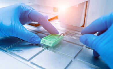 Laboratory assistant works at paraffin wax dispenser tissue embedding machine.