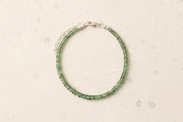 Emerald bracelet. Bracelet made of stones on hand from natural stone Emerald. Bracelet made of natural stones. Handmade jewelry. Handmade bracelets on light modern background