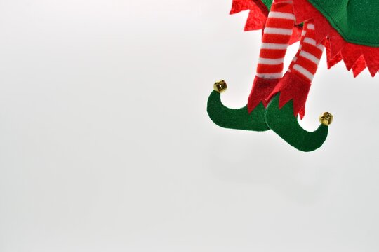 Piernas de elfo con zapatos verdes aislados en fondo blanco 