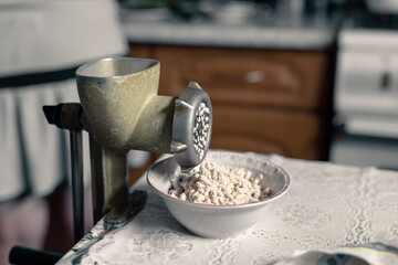 Old vintage meat grinder and minced meat in a plate. An old iron meat grinder from the USSR era