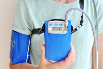 Woman wearing holter monitor device for daily monitoring of an electrocardiogram. Health care and...
