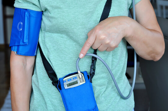 Woman wearing holter monitor device for daily monitoring of an electrocardiogram. Health care and disease prevention.the Patient shows the result