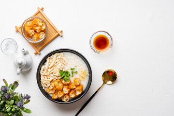 Traditional Chicken Porridge rice gruel in bowl shot on white background with negative space.