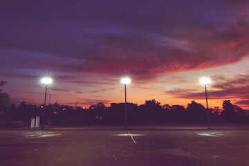 silhouette of outdoor light pole in empty local sport park with dramatic sky in the sunrise morning