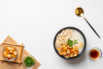 Traditional Chicken Porridge rice gruel in bowl shot on white background with negative space.