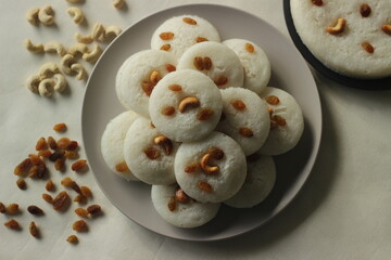 Vattappam in Idly shape. Steamed rice cake made of sweet fermented batter of rice and coconut, topped with raisins steamed using Idly mould.