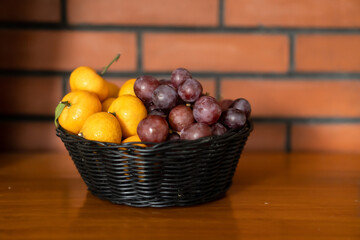 oranges and grapes on small basket