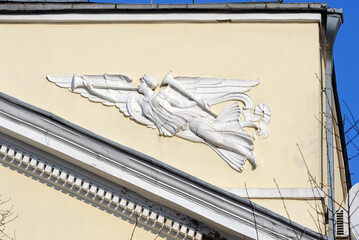 Trumpeting angel sculpture on the facade of old building in Kyiv Ukraine