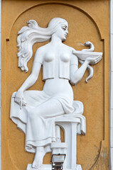The relief of a greek goddes with bowl of hygeia above the entrance to the old pharmacy in Lviv,...