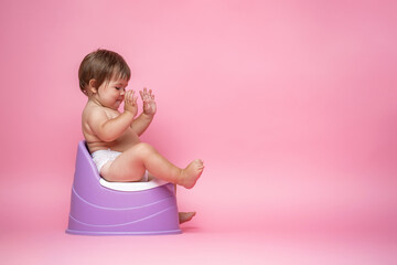 Cute baby in a diaper sitting on a potty. Toilet and potty training.
