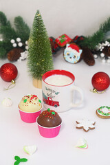 Christmas Choco Bomb and cup of hot milk, gingerbreads and other Christmas decorations, on light background.
