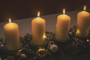 Fourth advent, four candles - candlelight on dark brown panorama background - advent banner. Horizontal banner for homepage. Template for greeting cards, funeral cards and obituaries.