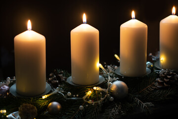 Fourth advent, four candles - candlelight on dark brown panorama background - advent banner. Horizontal banner for homepage. Template for greeting cards, funeral cards and obituaries.