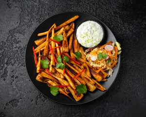 Spicy roast parsnips with zesty yogurt dip, vegetarian food.