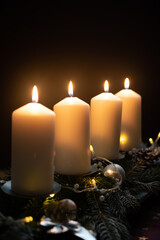 Fourth advent, four candles - candlelight on dark brown panorama background - advent banner. Horizontal banner for homepage. Template for greeting cards, funeral cards and obituaries.